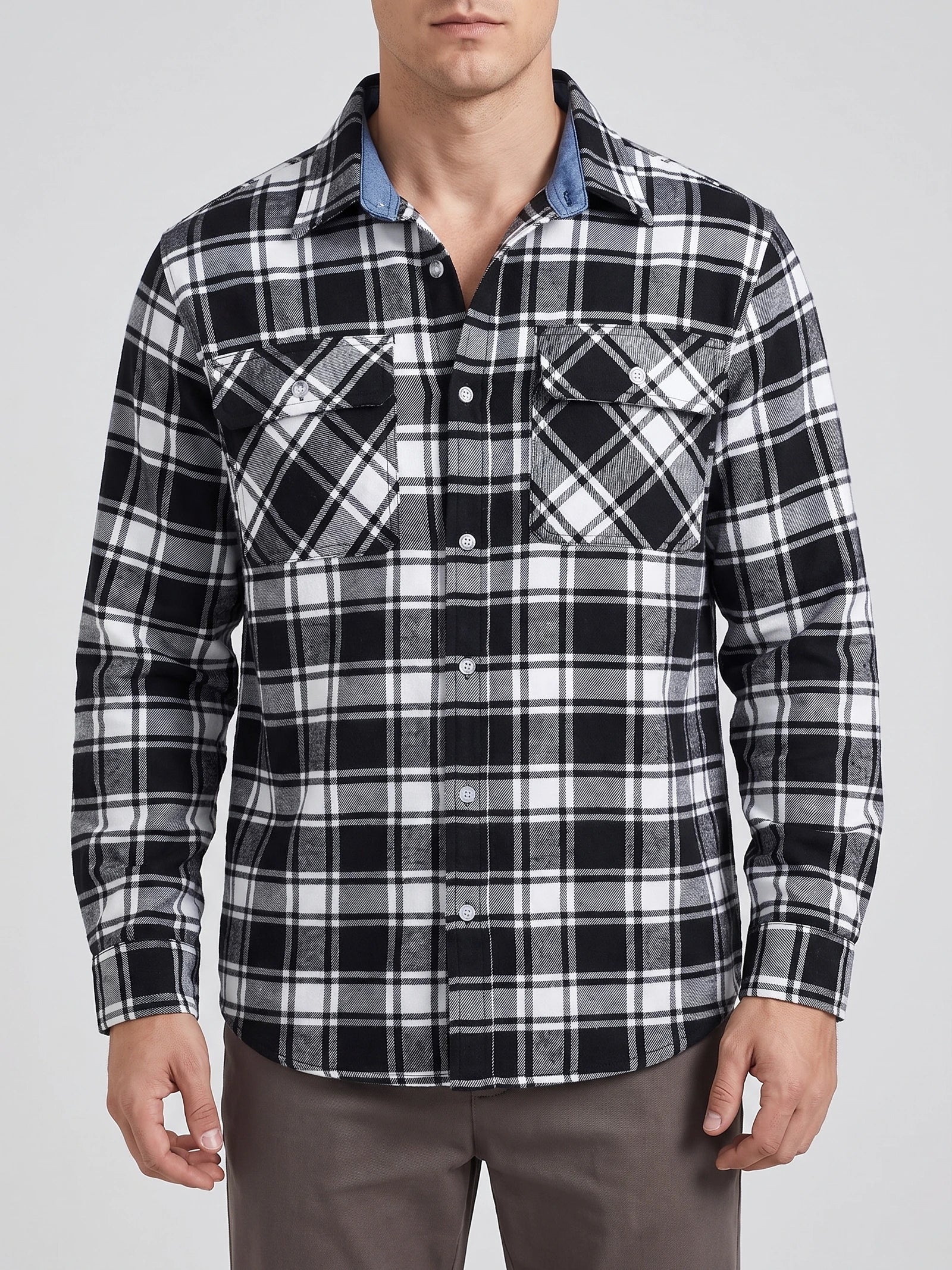 Front studio view of a model wearing a Black plaid flannel shirt with a button front, long sleeves, and two flap chest pockets.