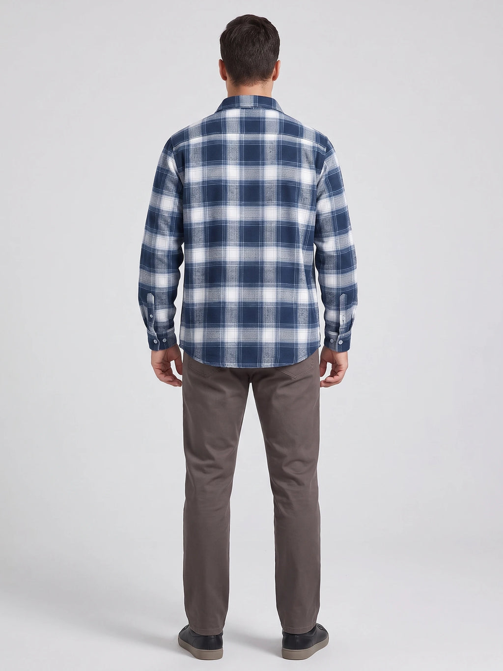 Rear studio view of a model wearing a Blue plaid flannel shirt with long sleeves and button cuffs.