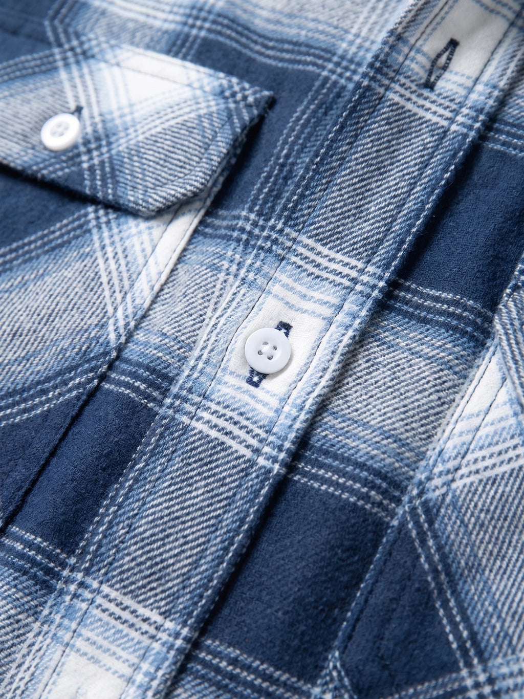Close-up of the Blue Plaid Flannel Shirt showing its button placket, stitching, and woven fabric texture.
