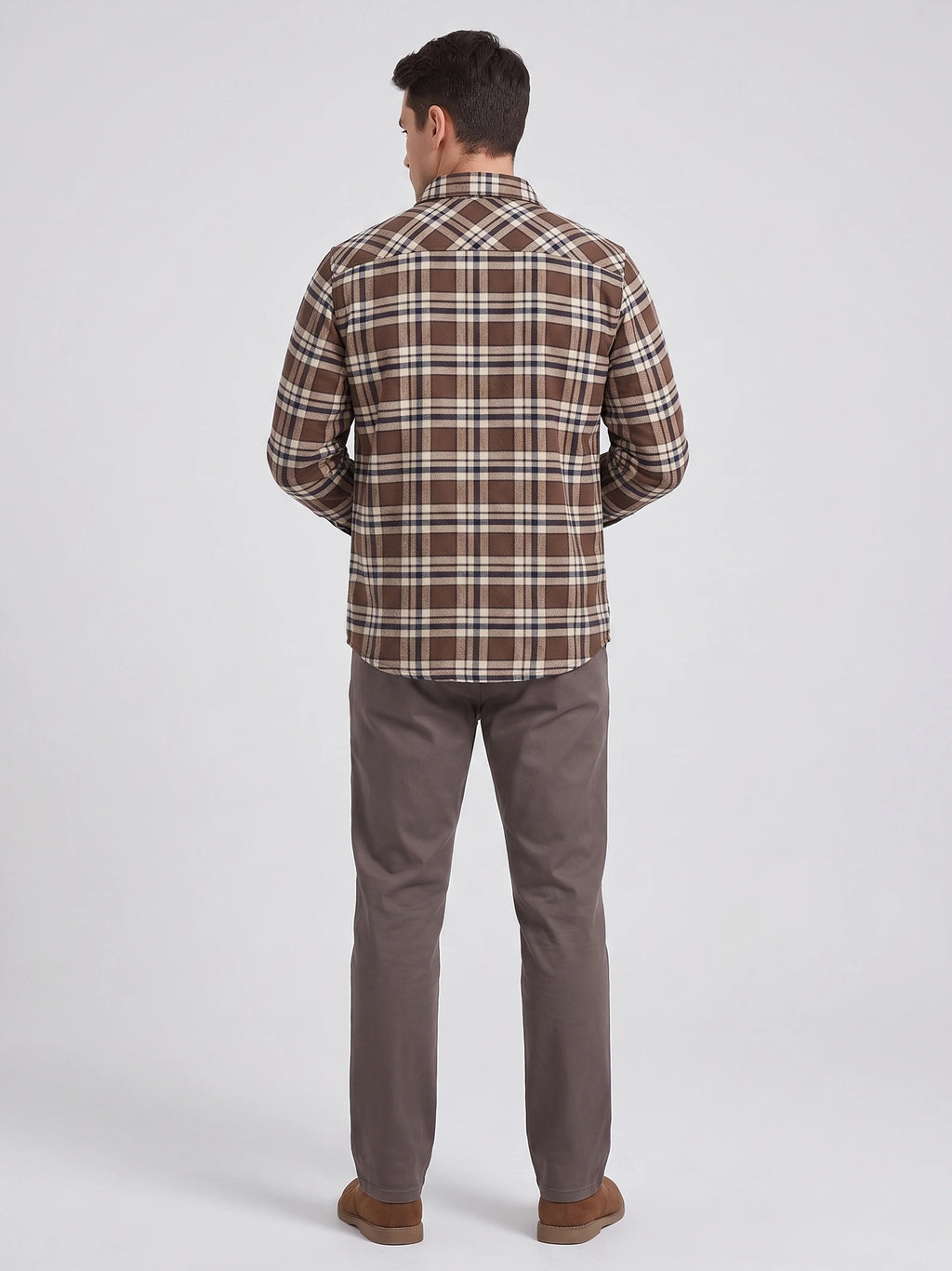 Rear studio view of a model wearing a Brown plaid flannel shirt jacket with long sleeves and a curved hem.