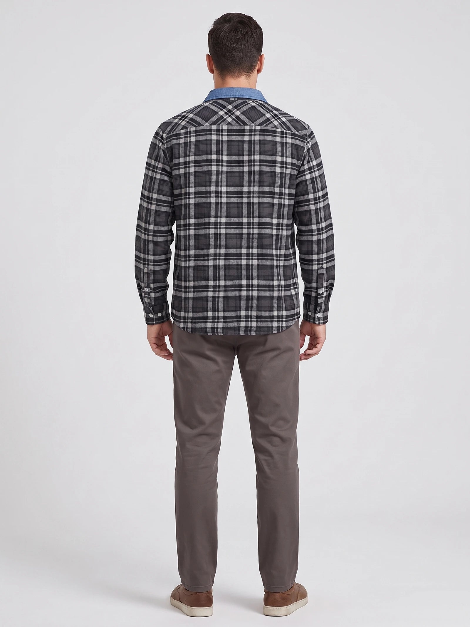 Rear studio view of a model wearing a Dark Gray plaid flannel shirt with long sleeves and button cuffs.