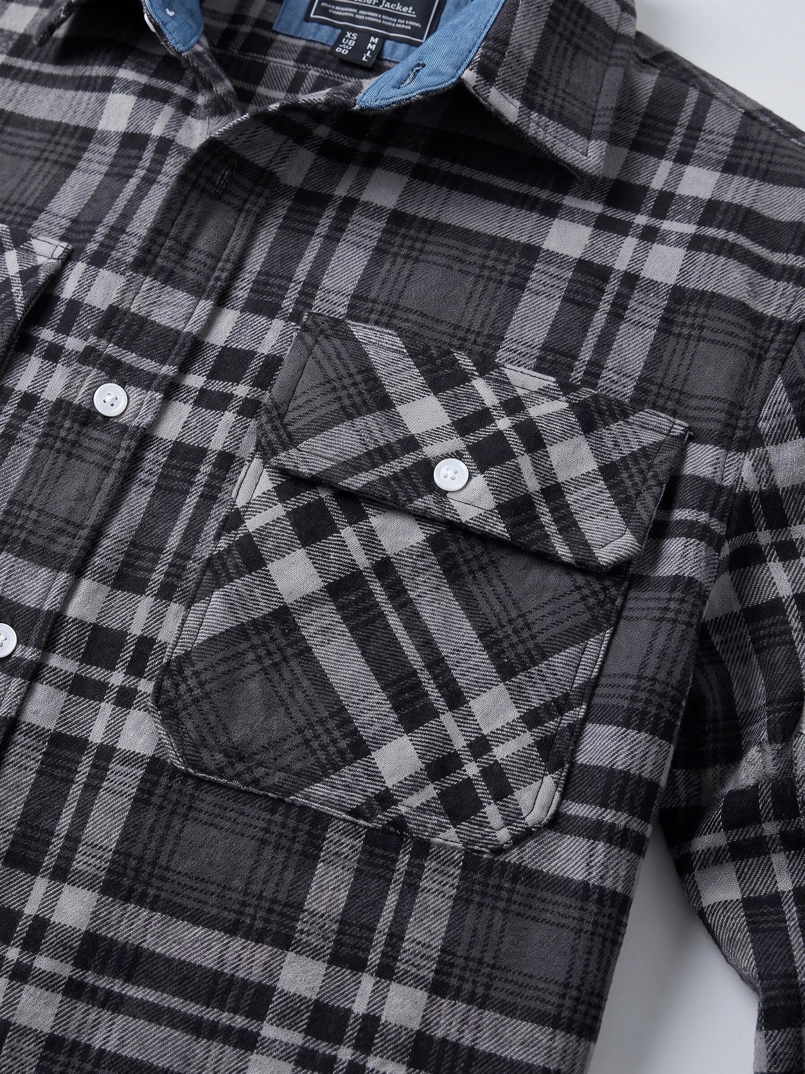 Close-up of the Dark Gray Plaid Flannel Shirt showing button-flap chest pockets, collar, and textured plaid fabric.
