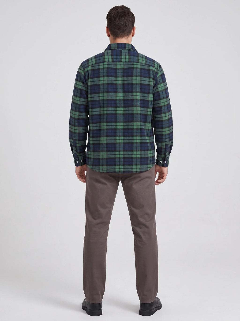 Rear studio view of a model wearing a Green plaid flannel shirt with long sleeves and a curved hem.