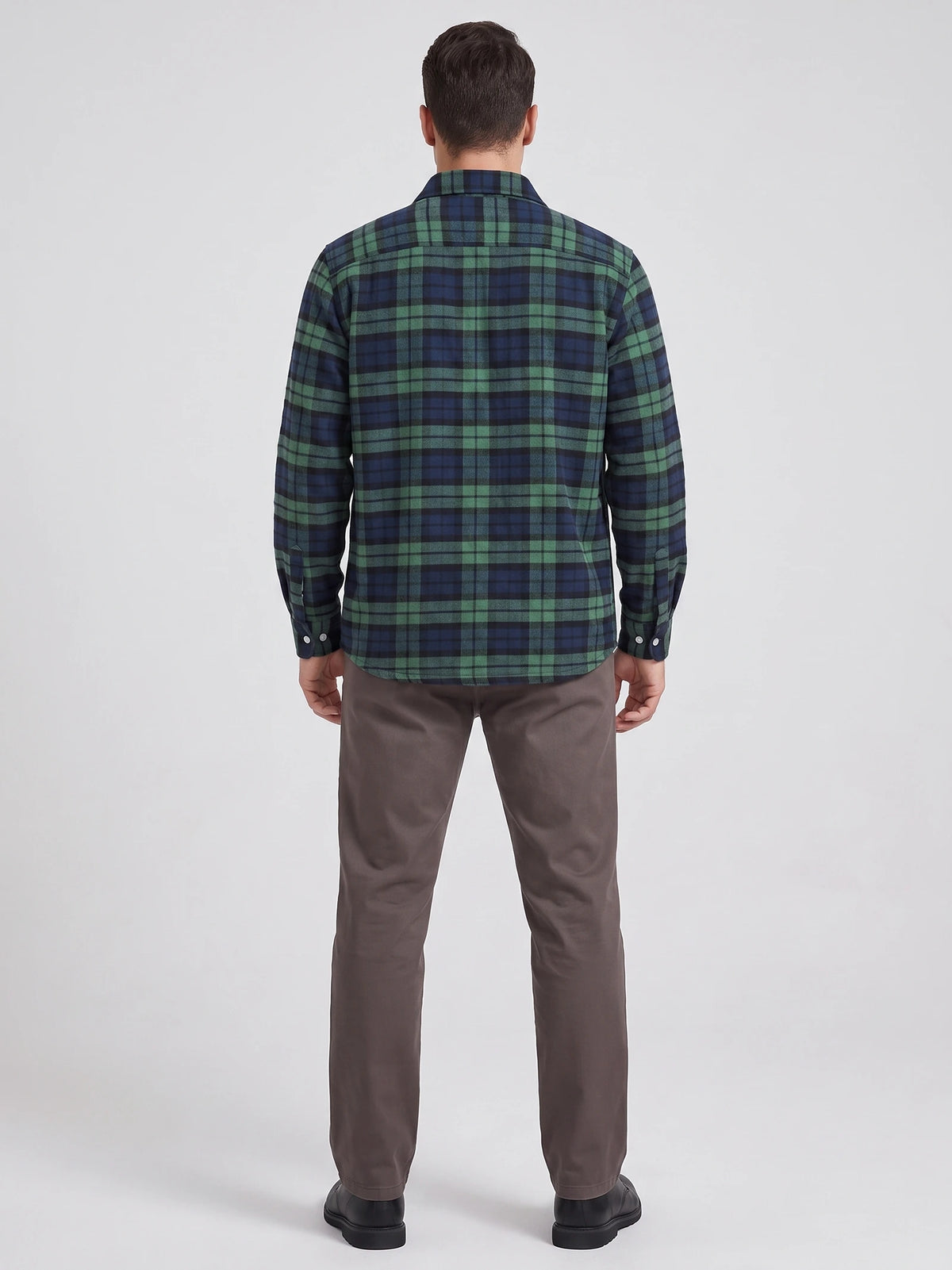 Rear studio view of a model wearing a Green plaid flannel shirt with long sleeves and a curved hem.