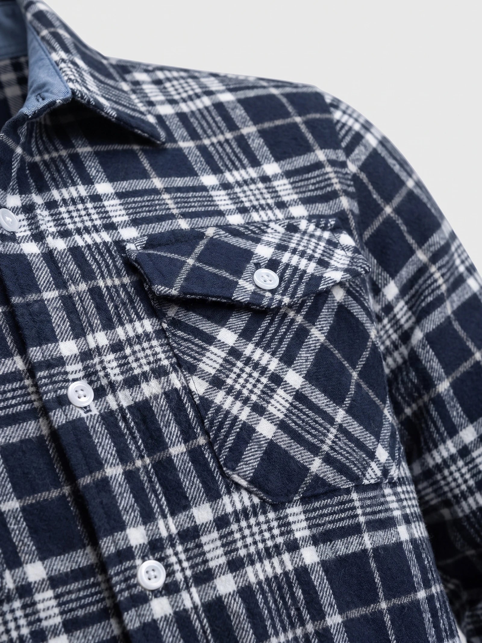 Close-up of the Navy Plaid Flannel Shirt showing the buttoned chest pocket, collar, and textured plaid fabric.