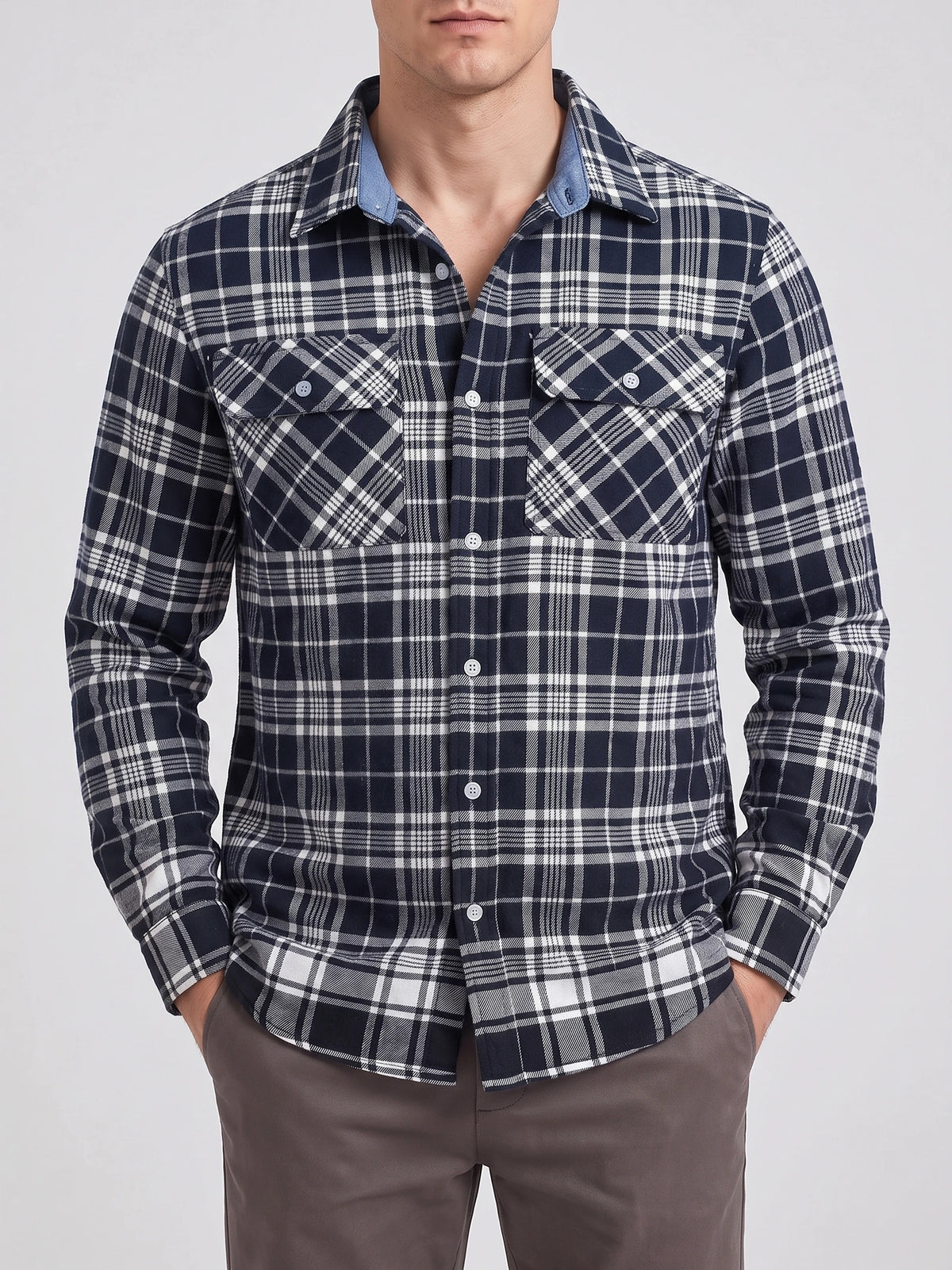 Front studio view of a model wearing a Navy plaid flannel shirt with long sleeves, button front, and two flap chest pockets.
