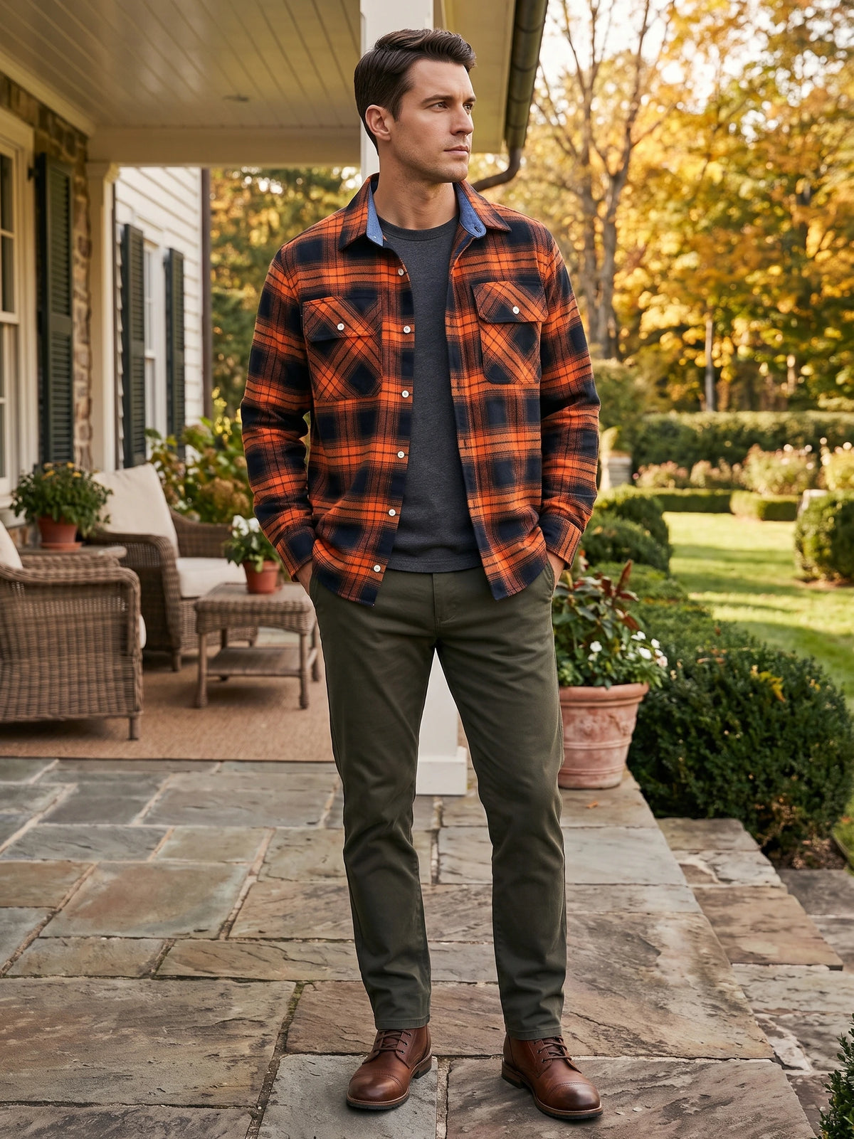Man wearing an Orange plaid flannel shirt jacket with buttoned chest pockets while standing on a garden patio.