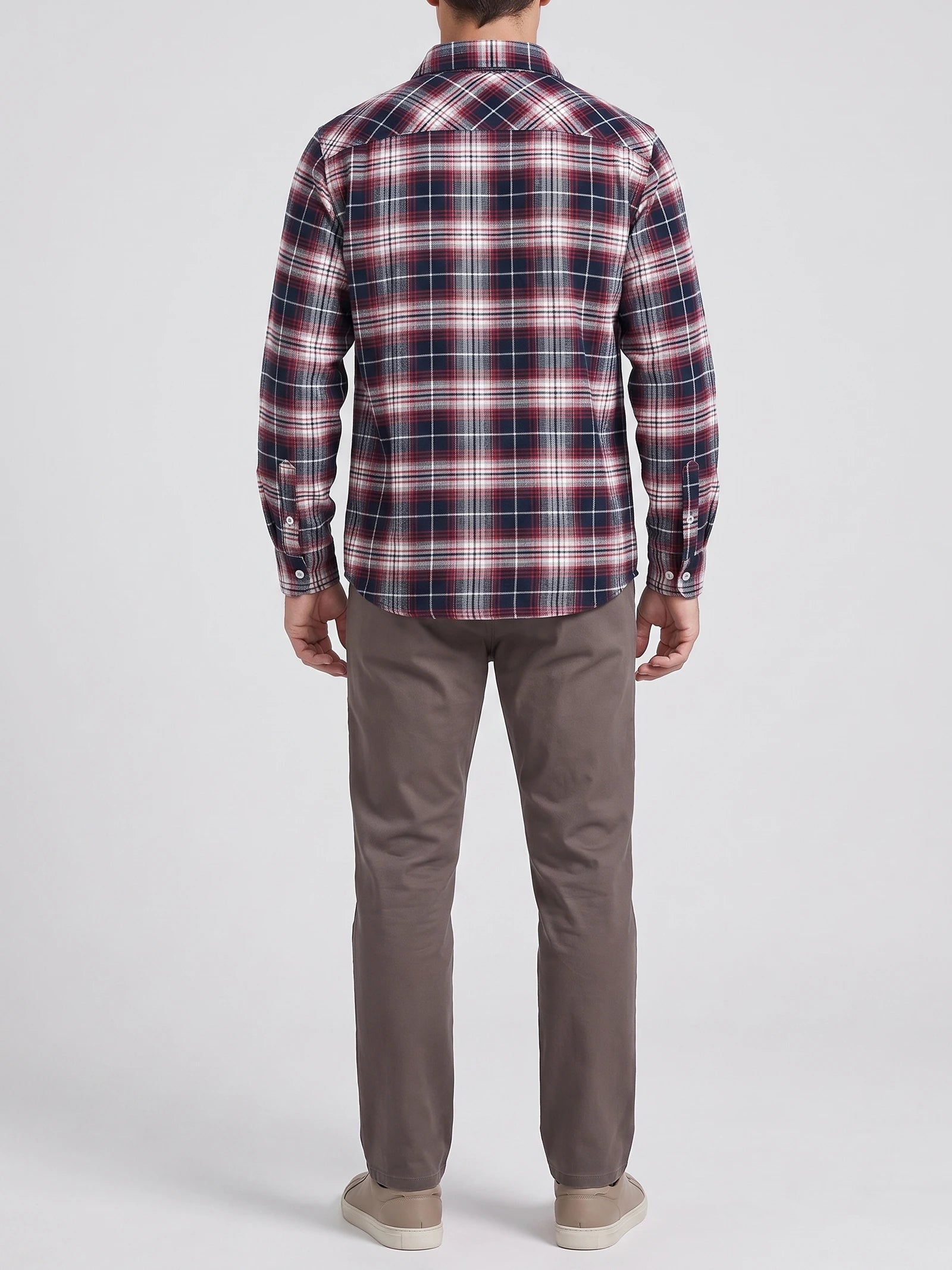 Rear studio view of a model wearing a Red plaid flannel shirt with long sleeves and a curved hem.