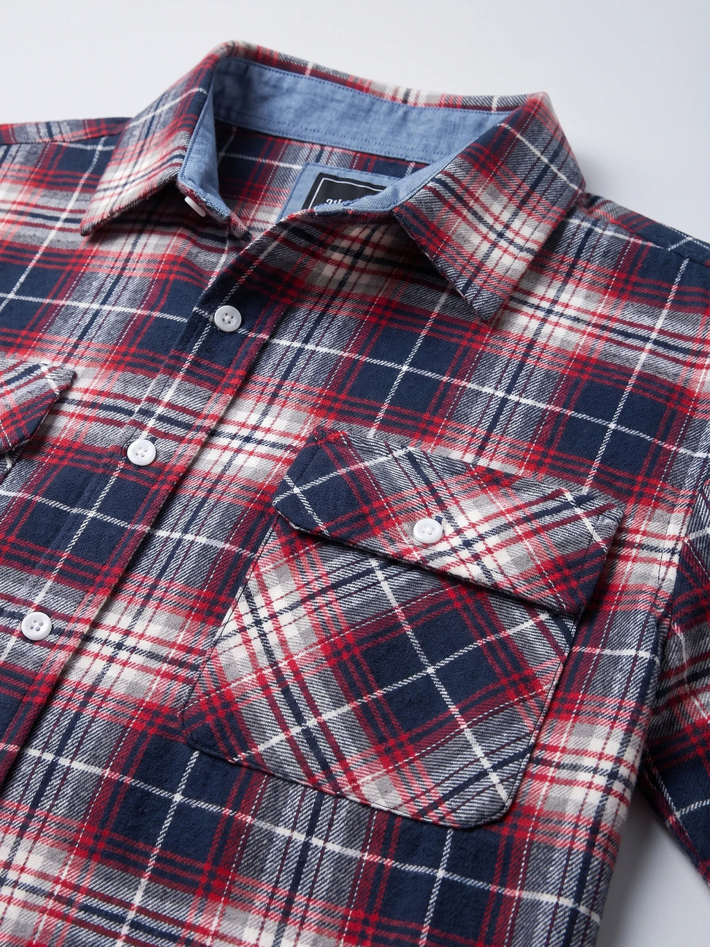Close-up of a Red plaid flannel shirt jacket showing the pointed collar, button front, and flap chest pocket.