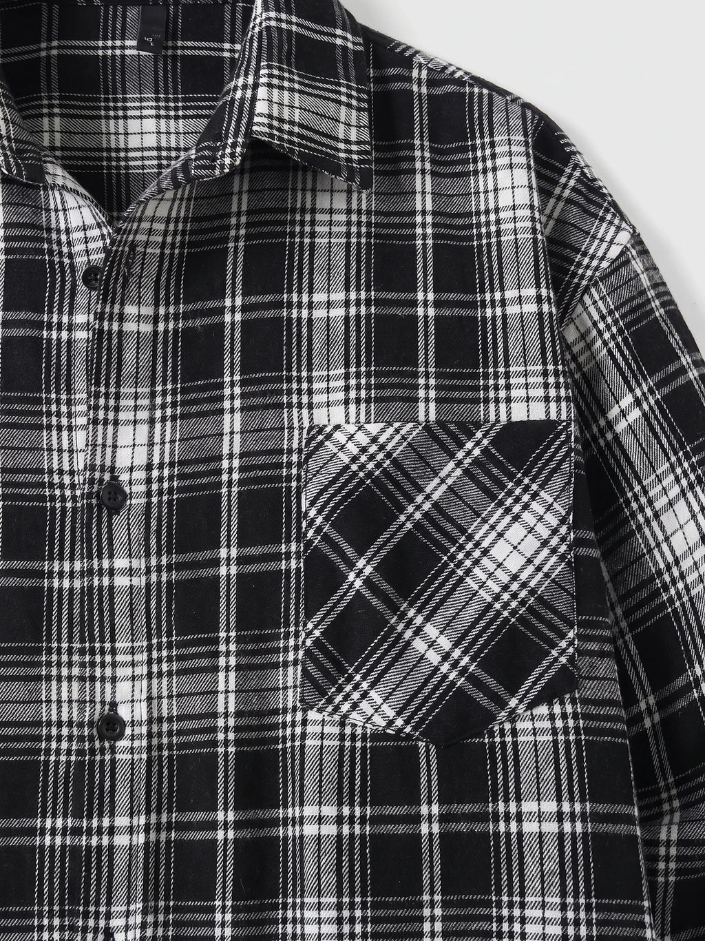 Close-up of a Black plaid Flannel Shirt showing the pointed collar, button front, and angled chest pocket.