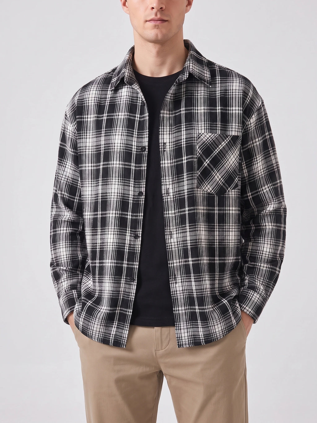 Model wearing a Black plaid Flannel Shirt with long sleeves, button front, and chest pocket in a front studio view.