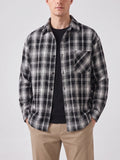 Model wearing a Black plaid Flannel Shirt with long sleeves, button front, and chest pocket in a front studio view.