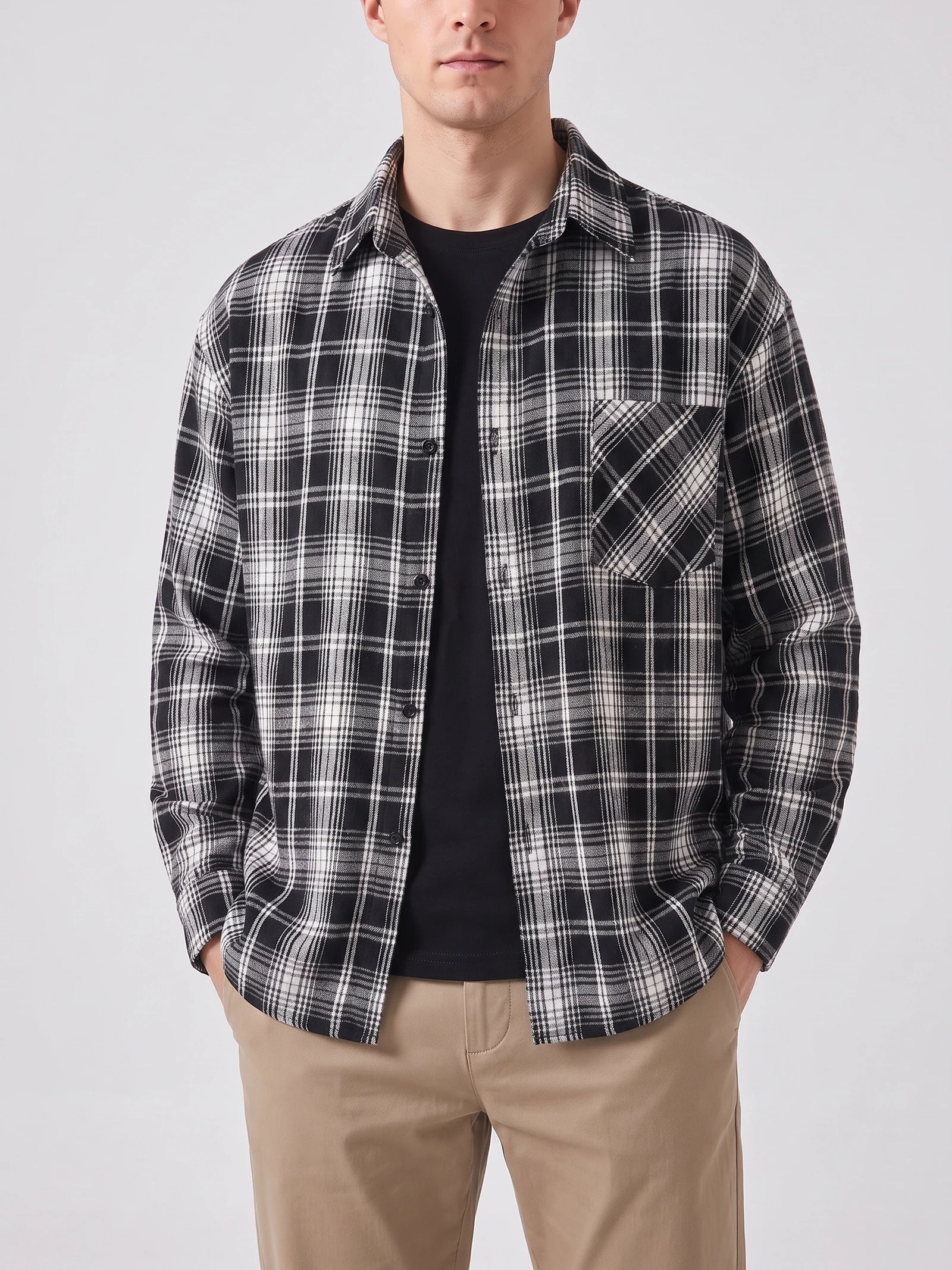 Model wearing a Black plaid Flannel Shirt with long sleeves, button front, and chest pocket in a front studio view.