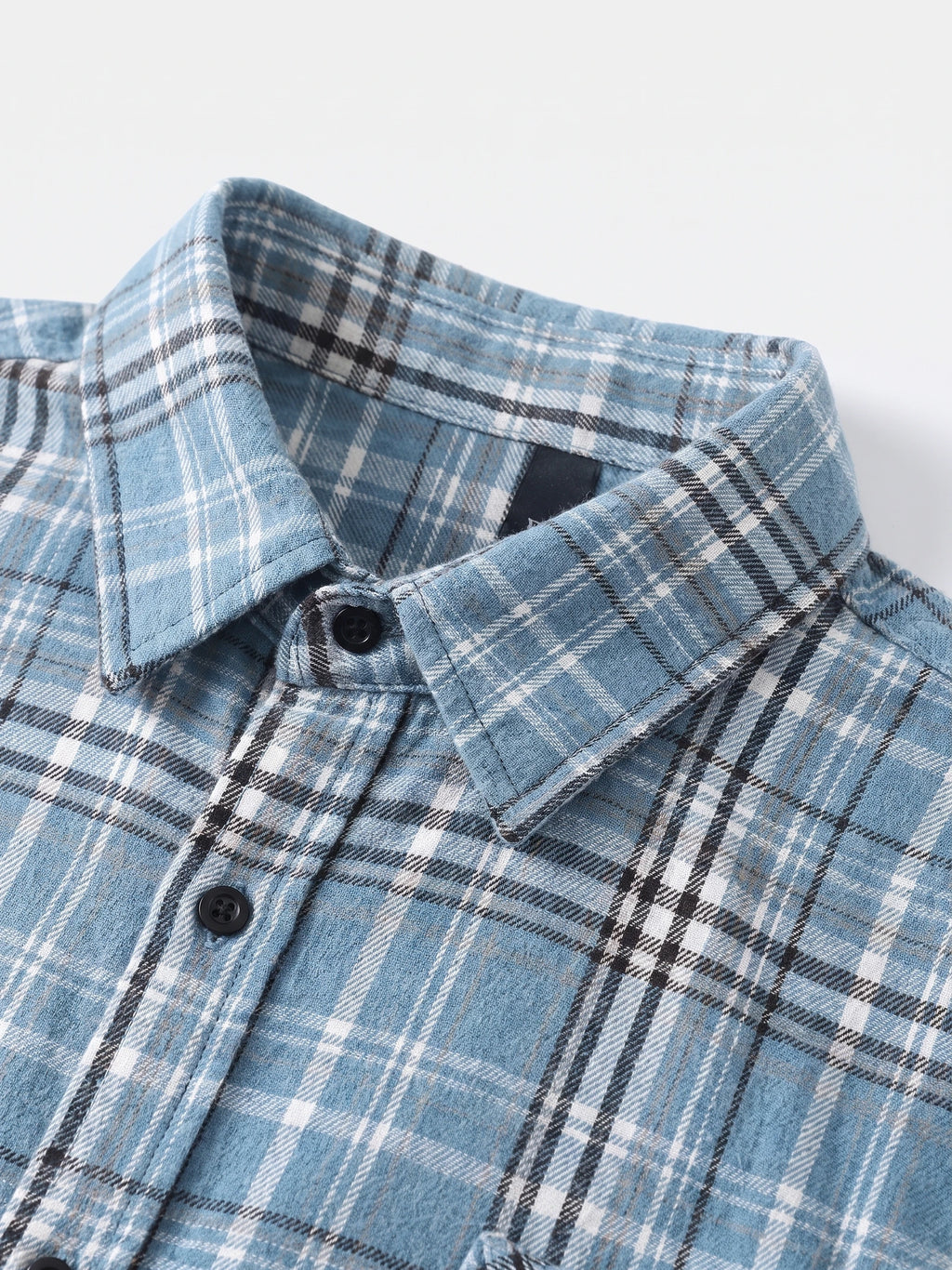 Close-up of the Blue plaid flannel shirt collar, button placket, and stitched chest pocket.