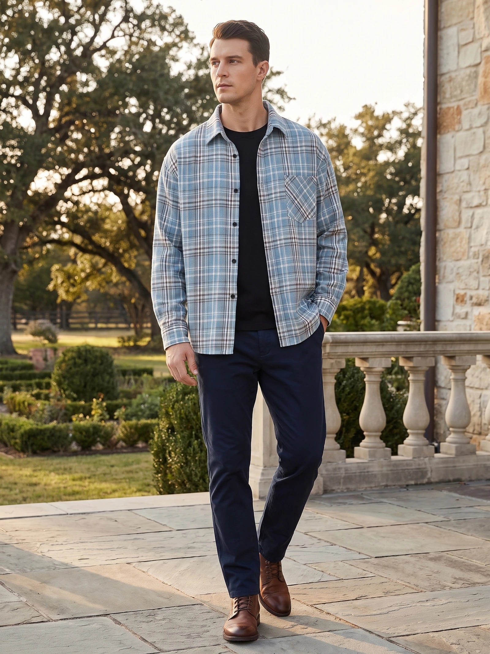Model walking beside a stone terrace in a Blue plaid Flannel Shirt with a chest pocket.
