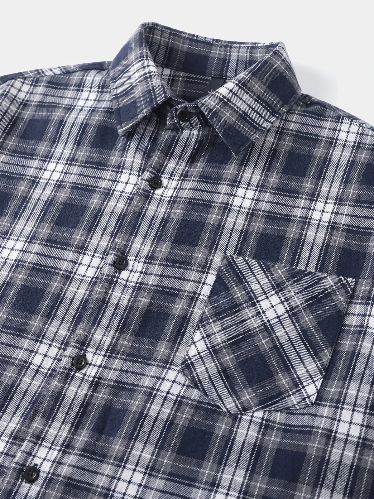 Close-up of a Navy plaid Flannel Shirt with a pointed collar, button front, and chest pocket.