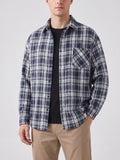 Front studio view of a model wearing a Navy plaid Flannel Shirt with long sleeves, button front, and chest pocket.