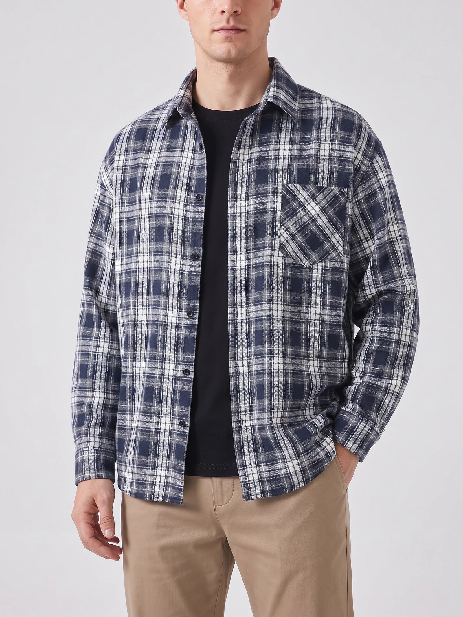 Front studio view of a model wearing a Navy plaid Flannel Shirt with long sleeves, button front, and chest pocket.