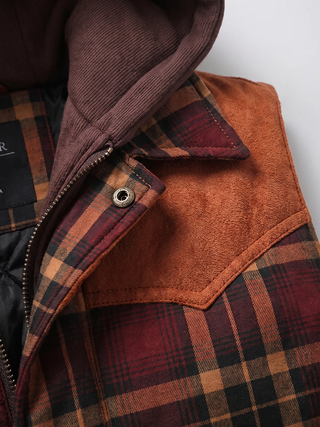 Red plaid Puffer Vest detail showing the zip front, snap flap, and soft-lined pocket.