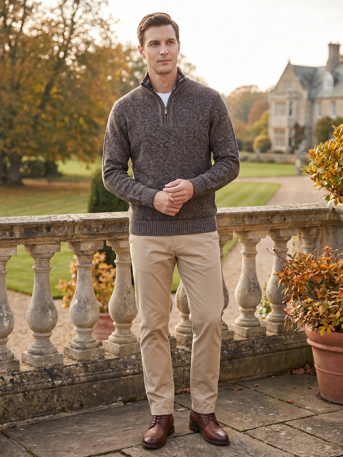 Model wearing a Brown Quarter Zip Sweater with ribbed cuffs and hem on a stone terrace overlooking a garden.