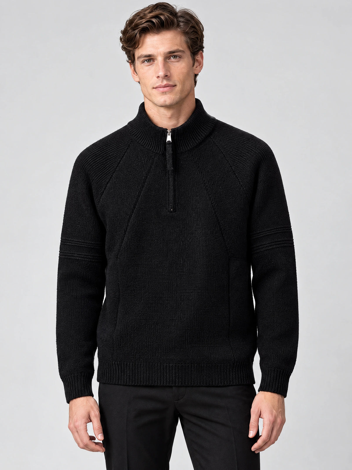 Front studio view of a model wearing a Black men's quarter zip sweater with a ribbed stand collar and textured knit panels.