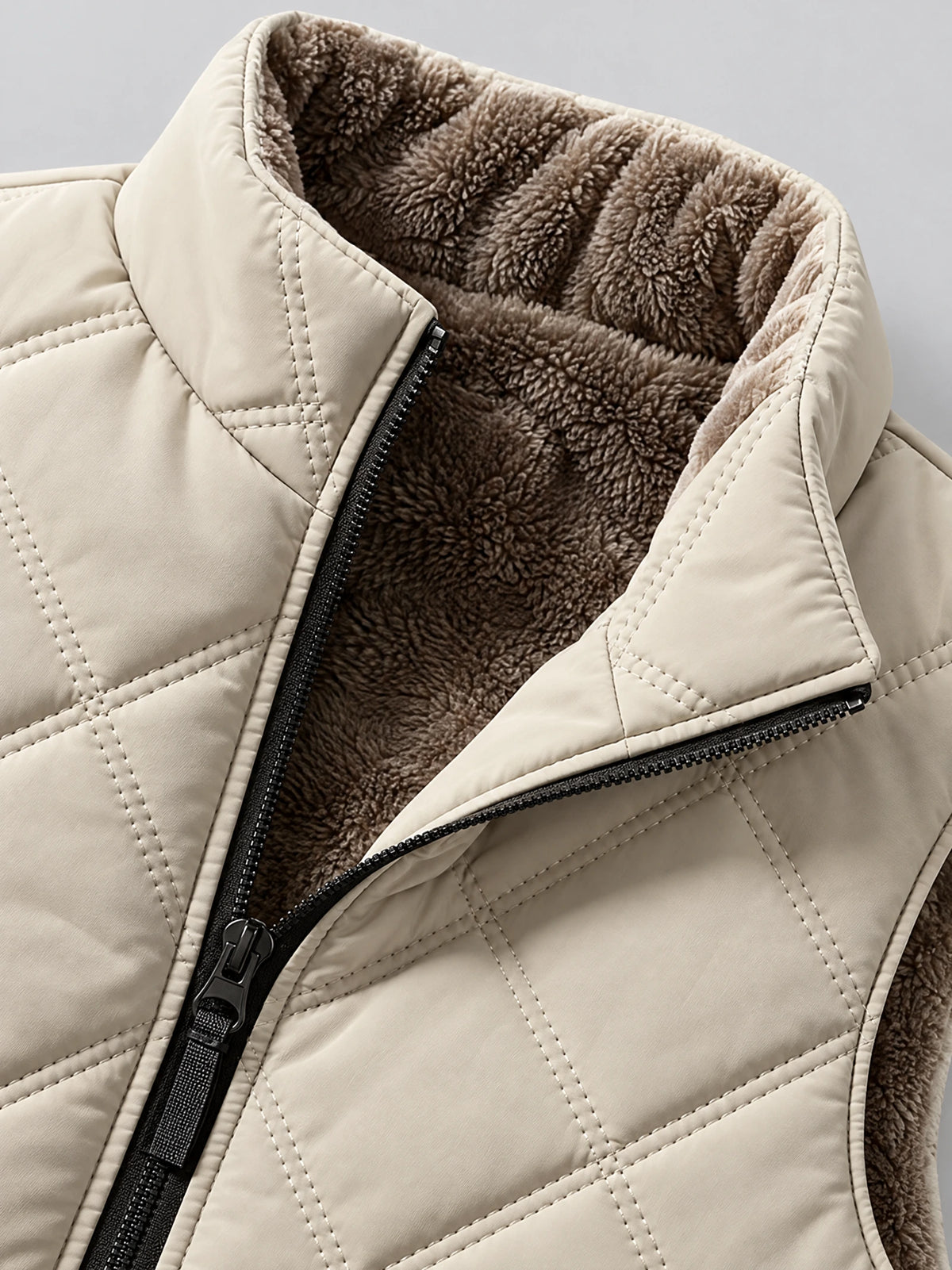 Close-up of the Beige Quilted Puffer Vest showing its fleece-lined stand collar, diamond stitching, and front zipper.