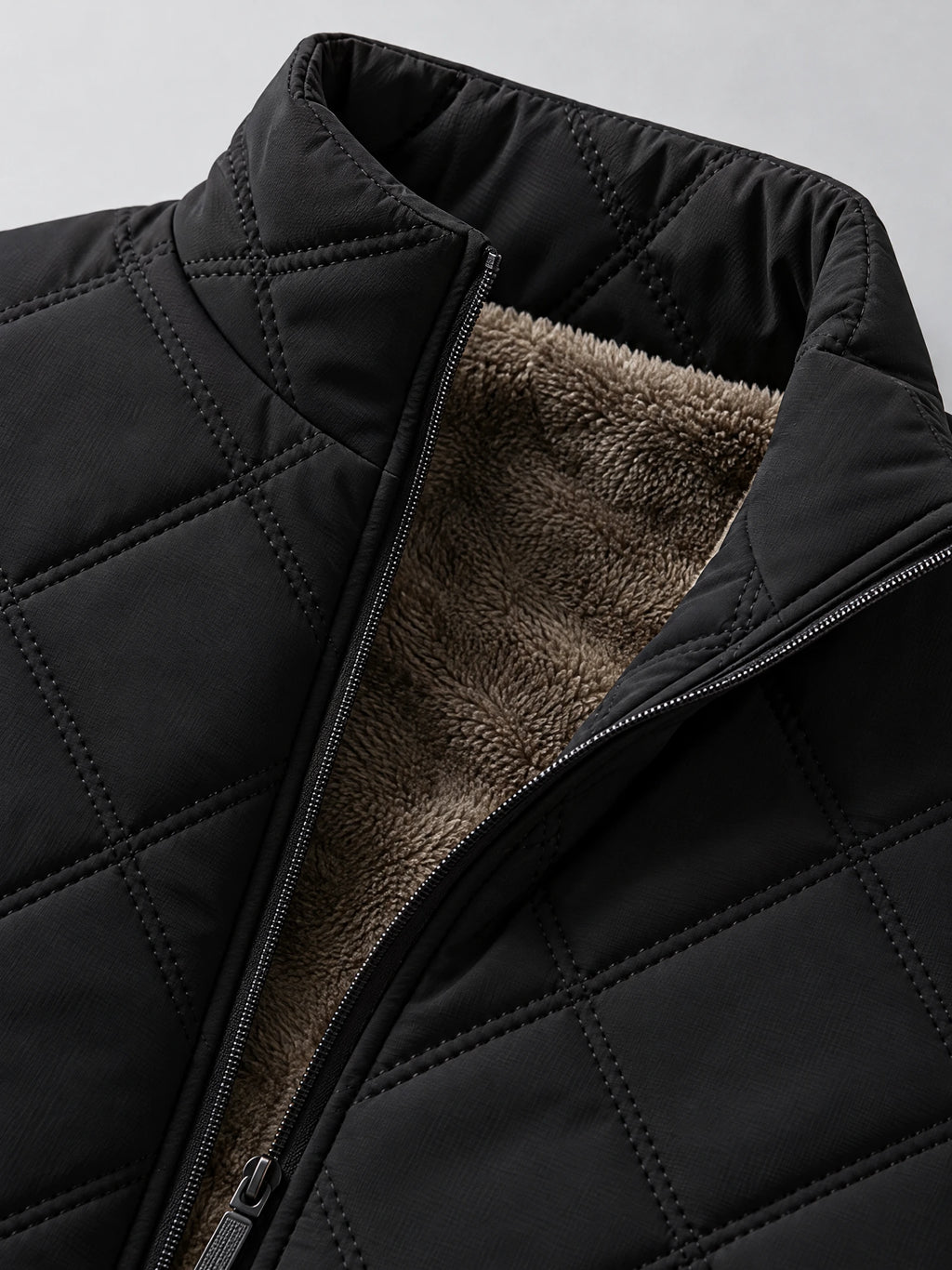 Close-up of the Black Quilted Puffer Vest with a stand collar, front zipper, quilted stitching, and fleece lining.