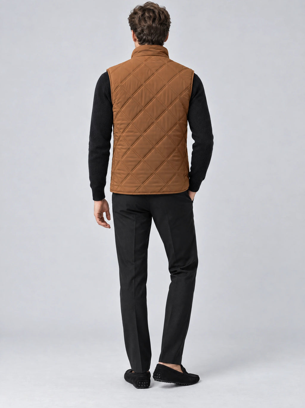 Rear studio view of a model wearing a Brown quilted puffer vest with diamond stitching and a stand collar.