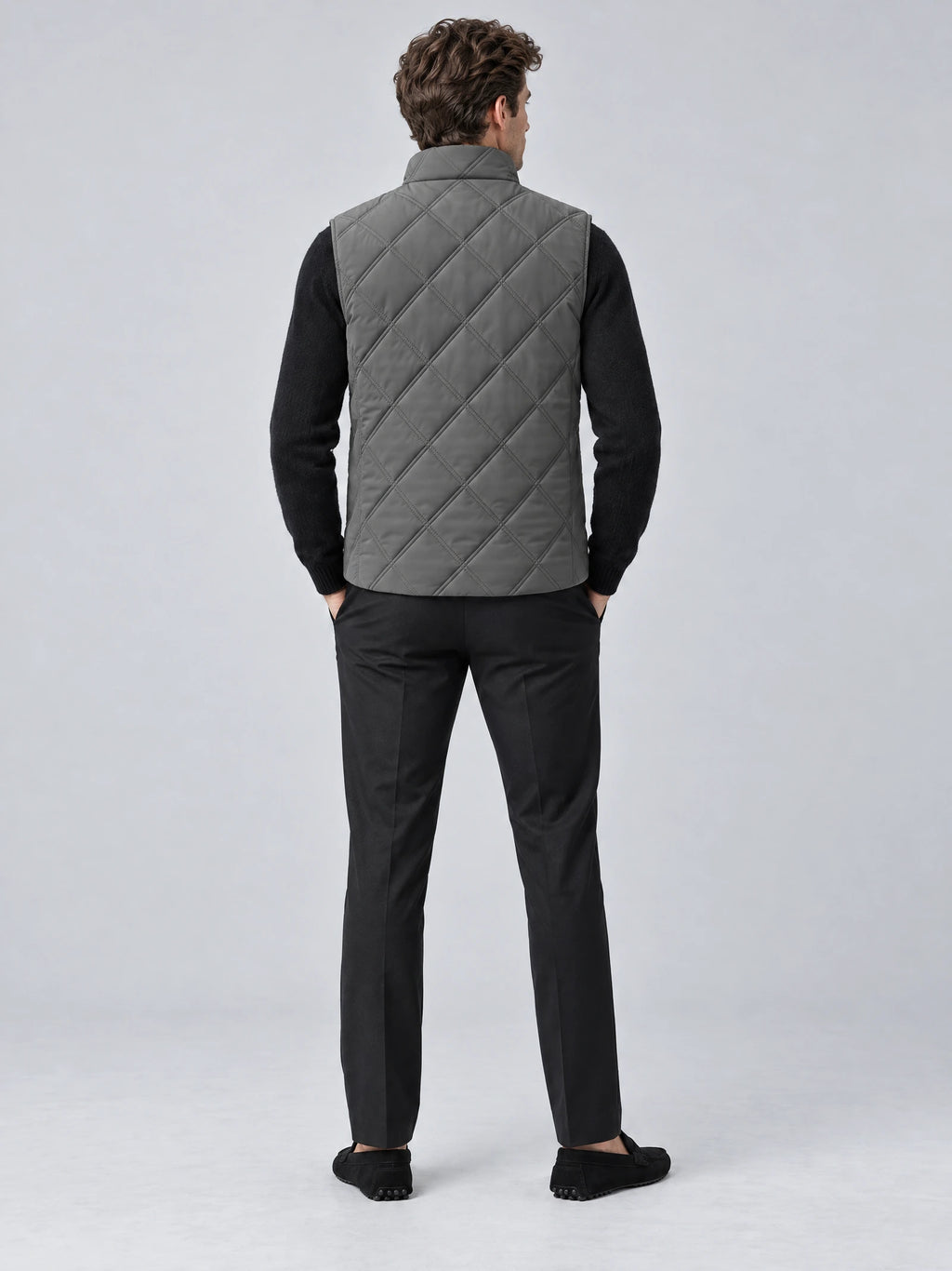 Rear studio view of a model wearing a Gray Quilted Puffer Vest with diamond stitching and a stand collar.