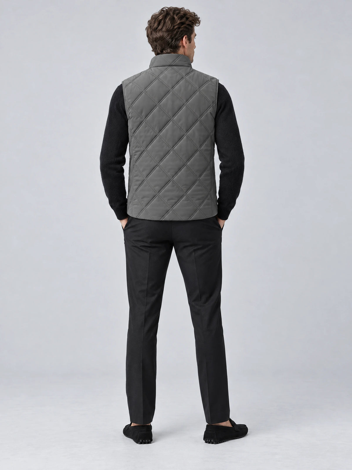 Rear studio view of a model wearing a Gray Quilted Puffer Vest with diamond stitching and a stand collar.