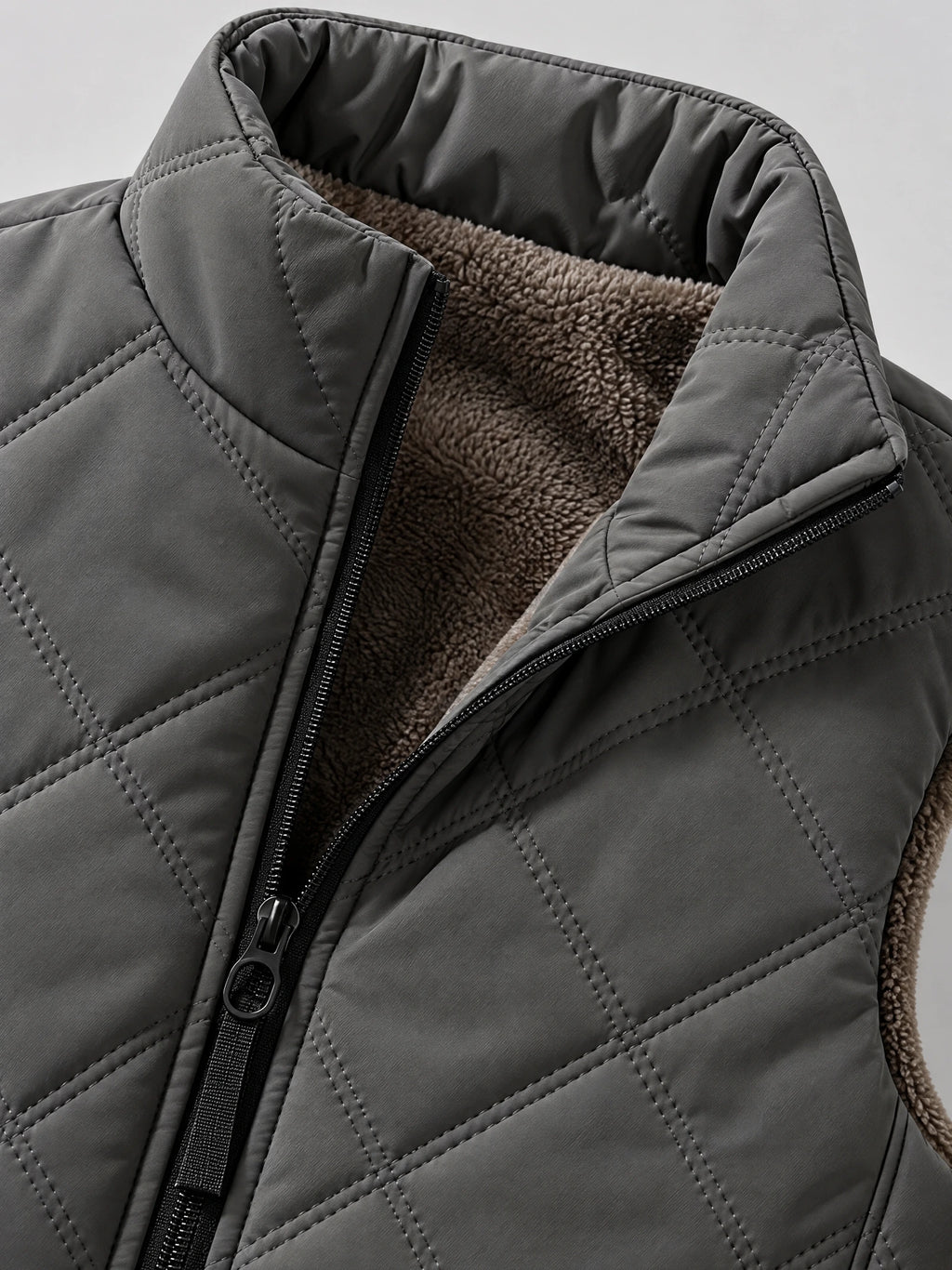 Close-up of the Gray Quilted Puffer Vest showing the zip-front, stand collar, diamond stitching, and fleece lining.