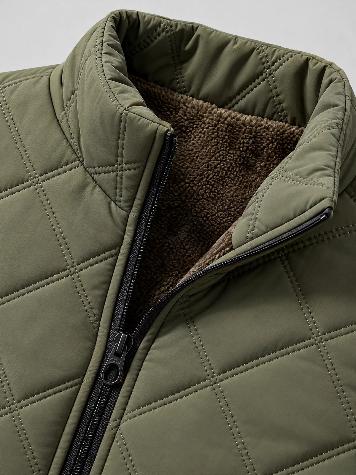 Close-up of the Green Quilted Puffer Vest showing the padded stand collar, front zipper, diamond stitching, and fleece lining.