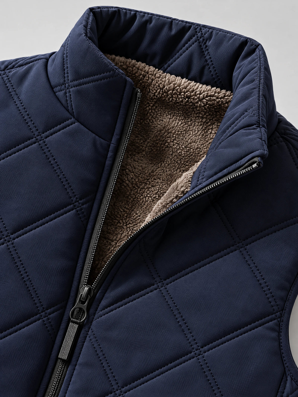Close-up of the Navy Quilted Puffer Vest showing the stand collar, front zipper, quilted stitching, and fleece lining.
