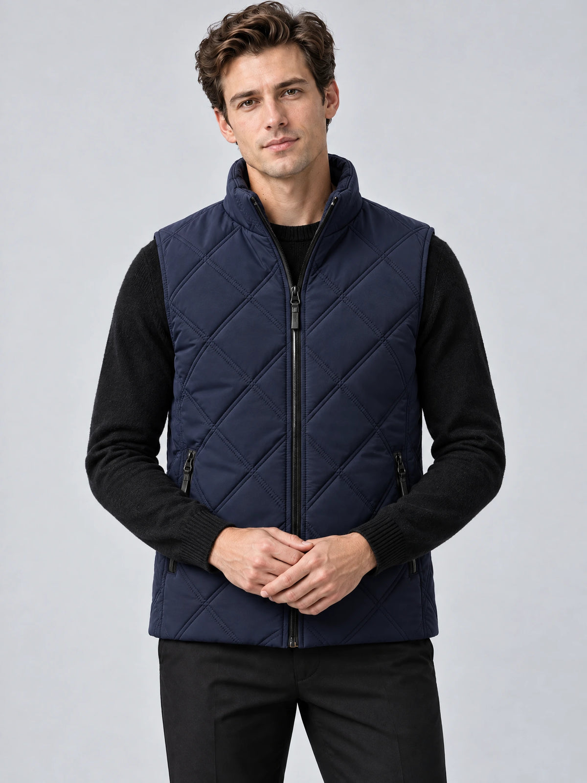 Front studio view of a model wearing a Navy quilted puffer vest with a stand collar, full zip closure, and zippered pockets.