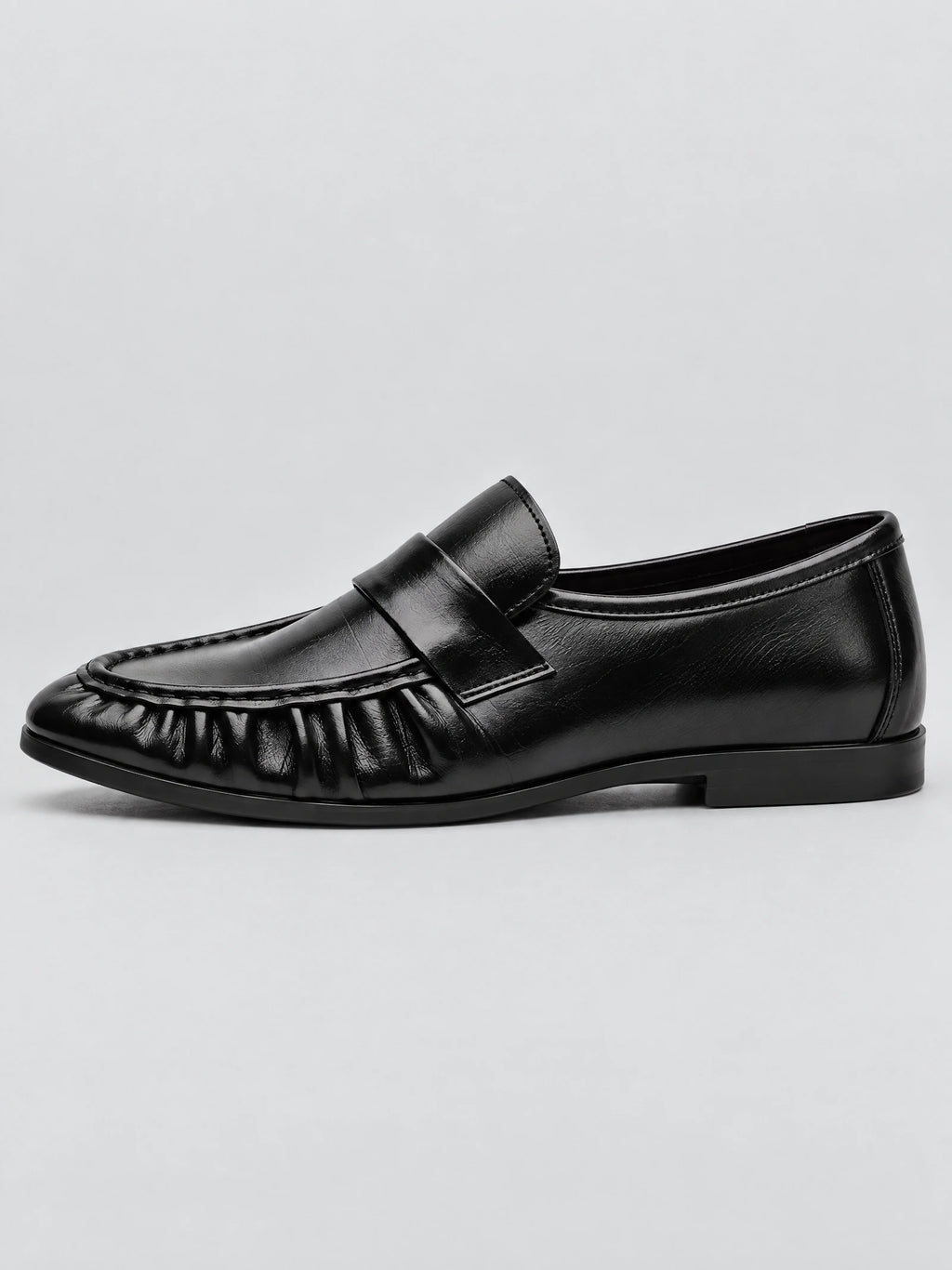 Side view of a Black ruched leather loafer with a stitched moc toe and slip-on strap.