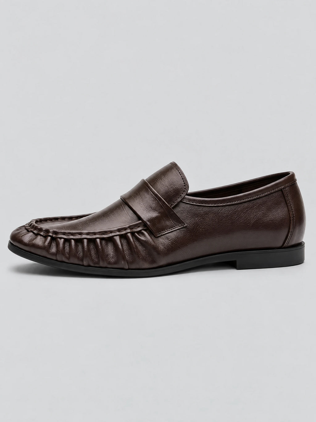Side view of Brown ruched leather loafers with a stitched apron toe and strap detail.