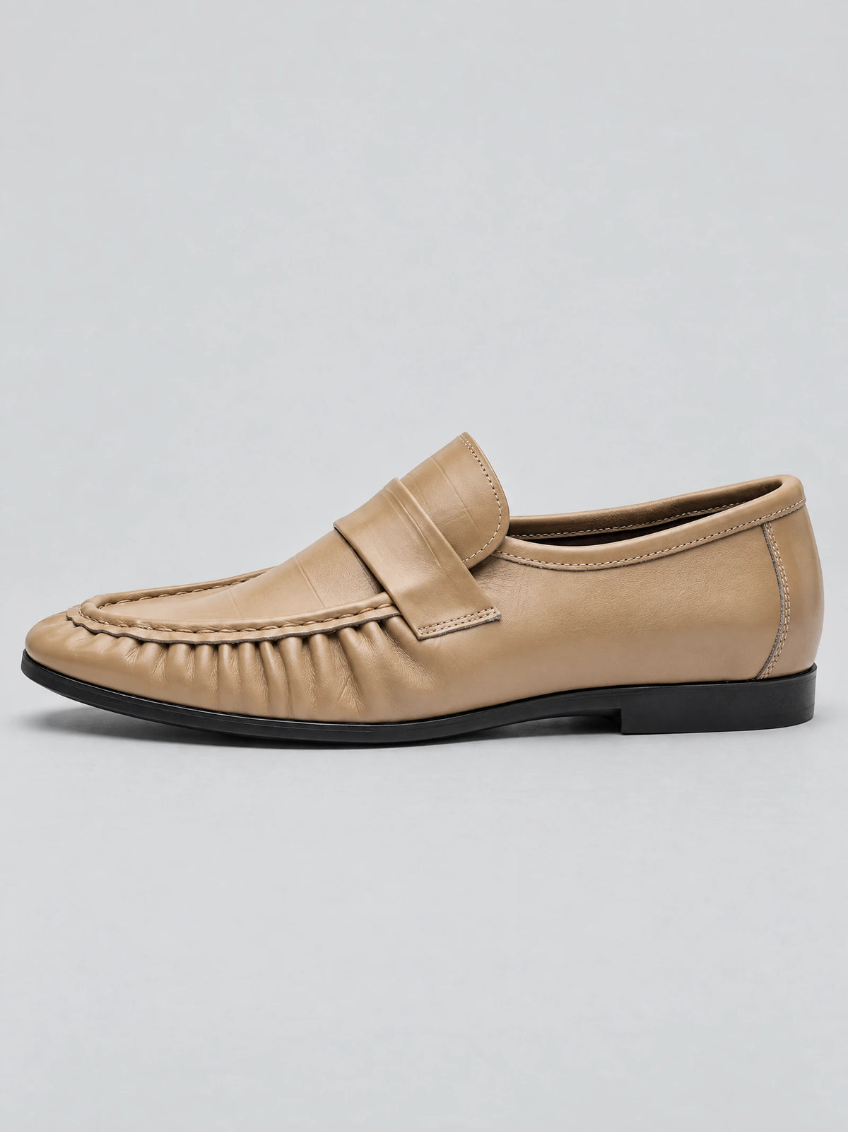 Side view of a Khaki ruched leather loafer with a stitched moc toe, wide instep strap, and low heel.