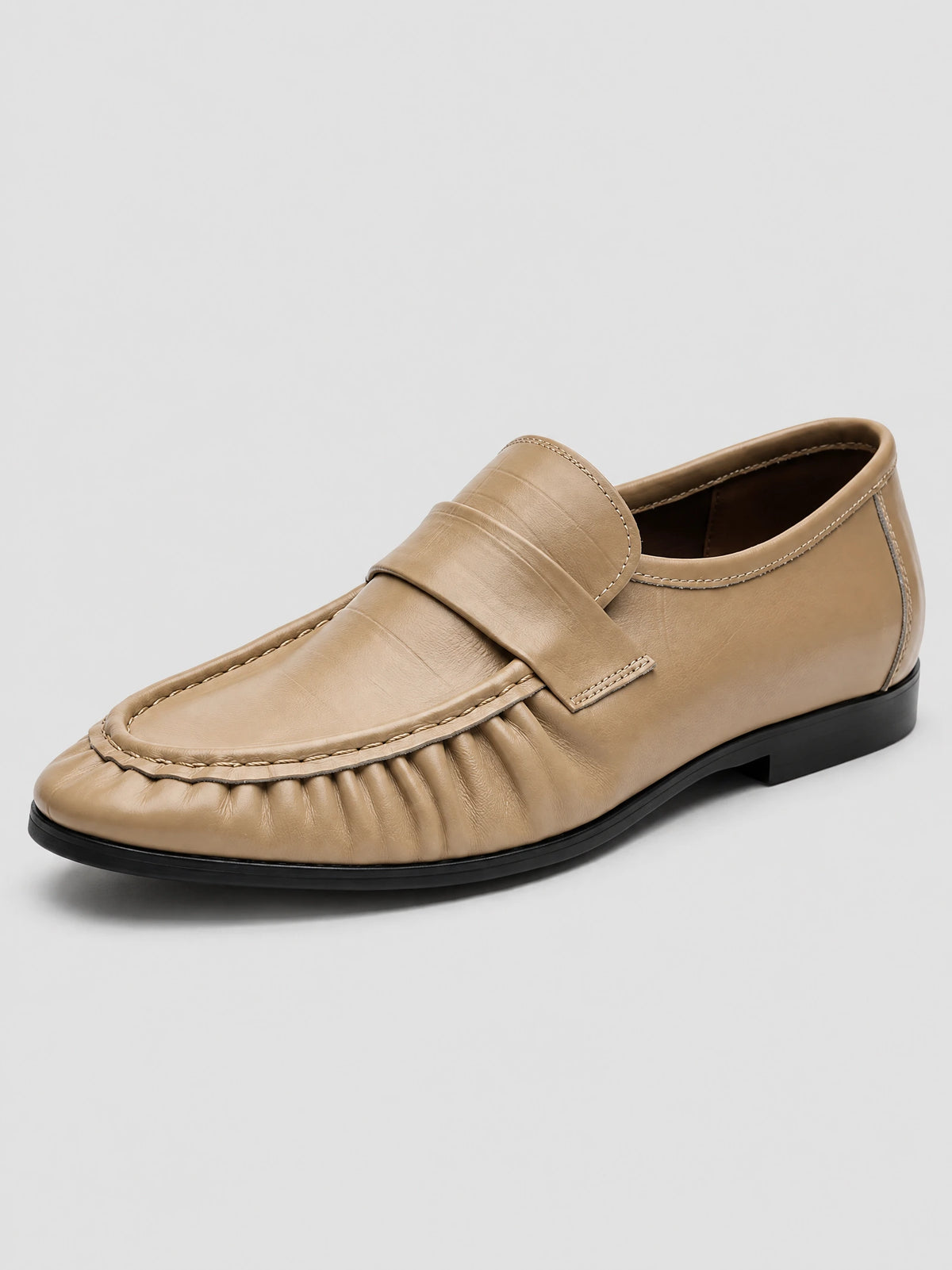 Khaki ruched leather loafer in a three-quarter studio view, showing the stitched moc toe, penny strap, and low sole.