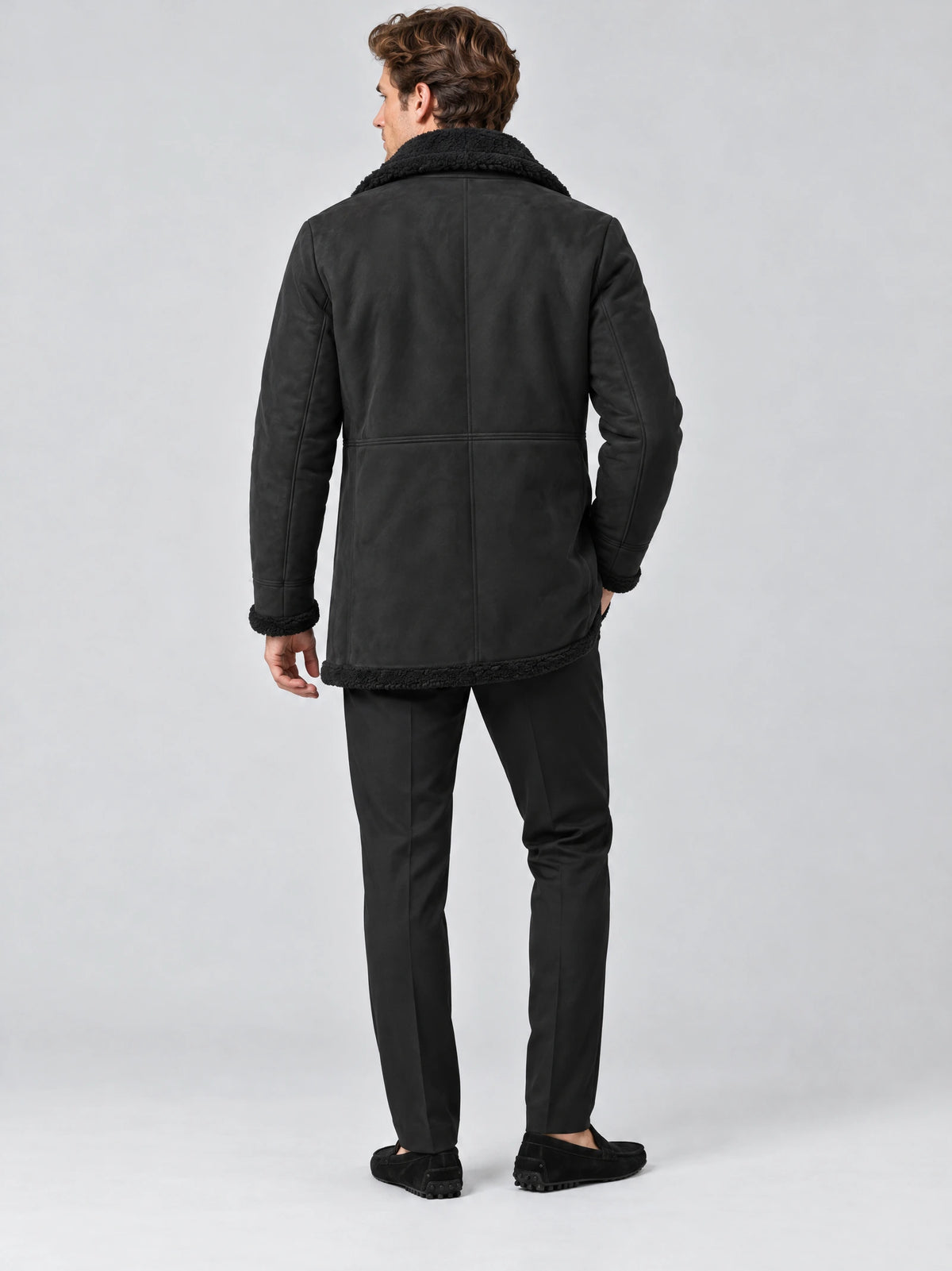 Rear studio view of a model wearing a Black Sherpa-lined jacket with a plush collar, cuffs, and hem.