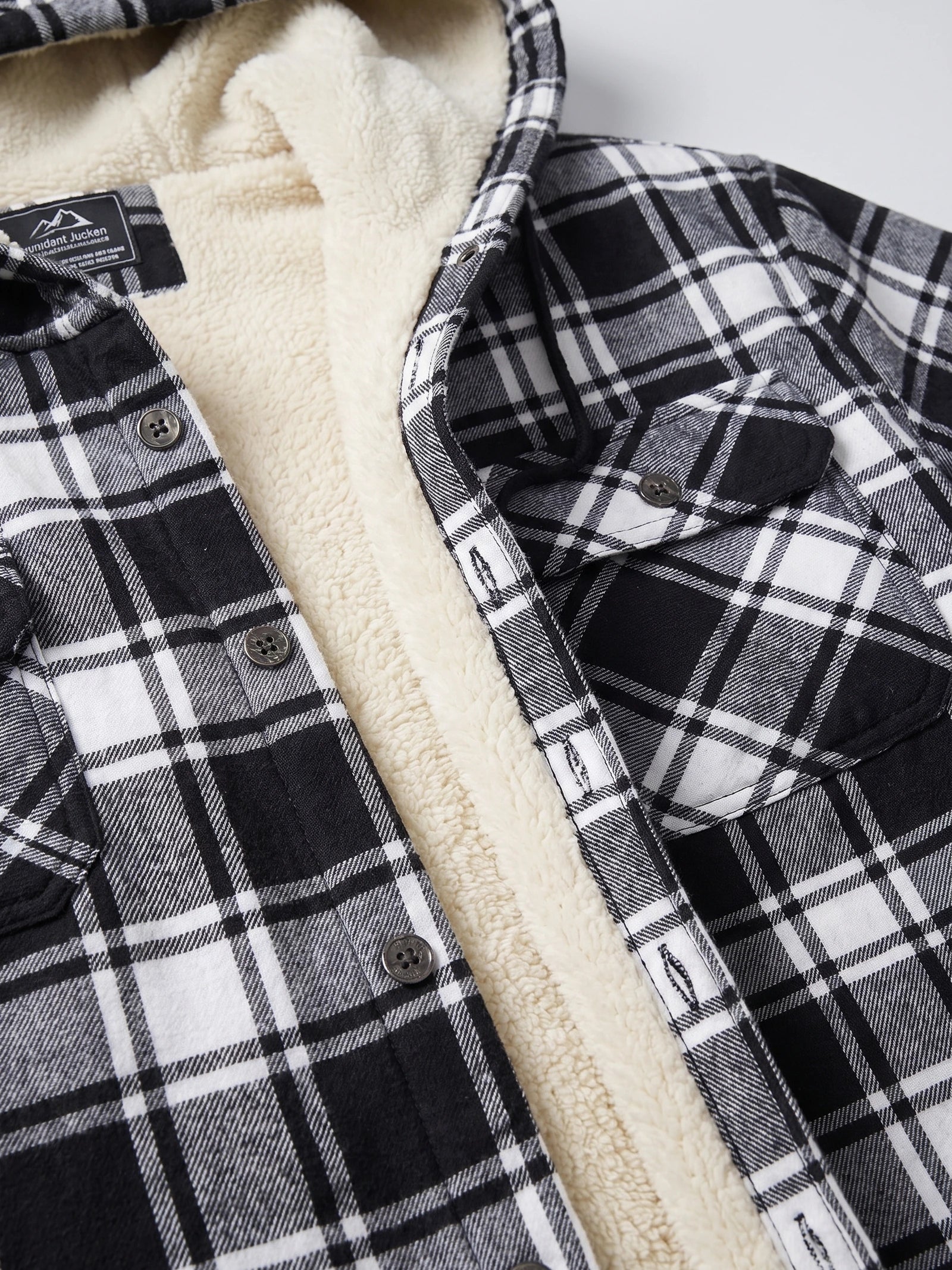 Close-up of the Black Sherpa Lined Jacket showing its soft lining, button-front placket, and buttoned chest pocket.