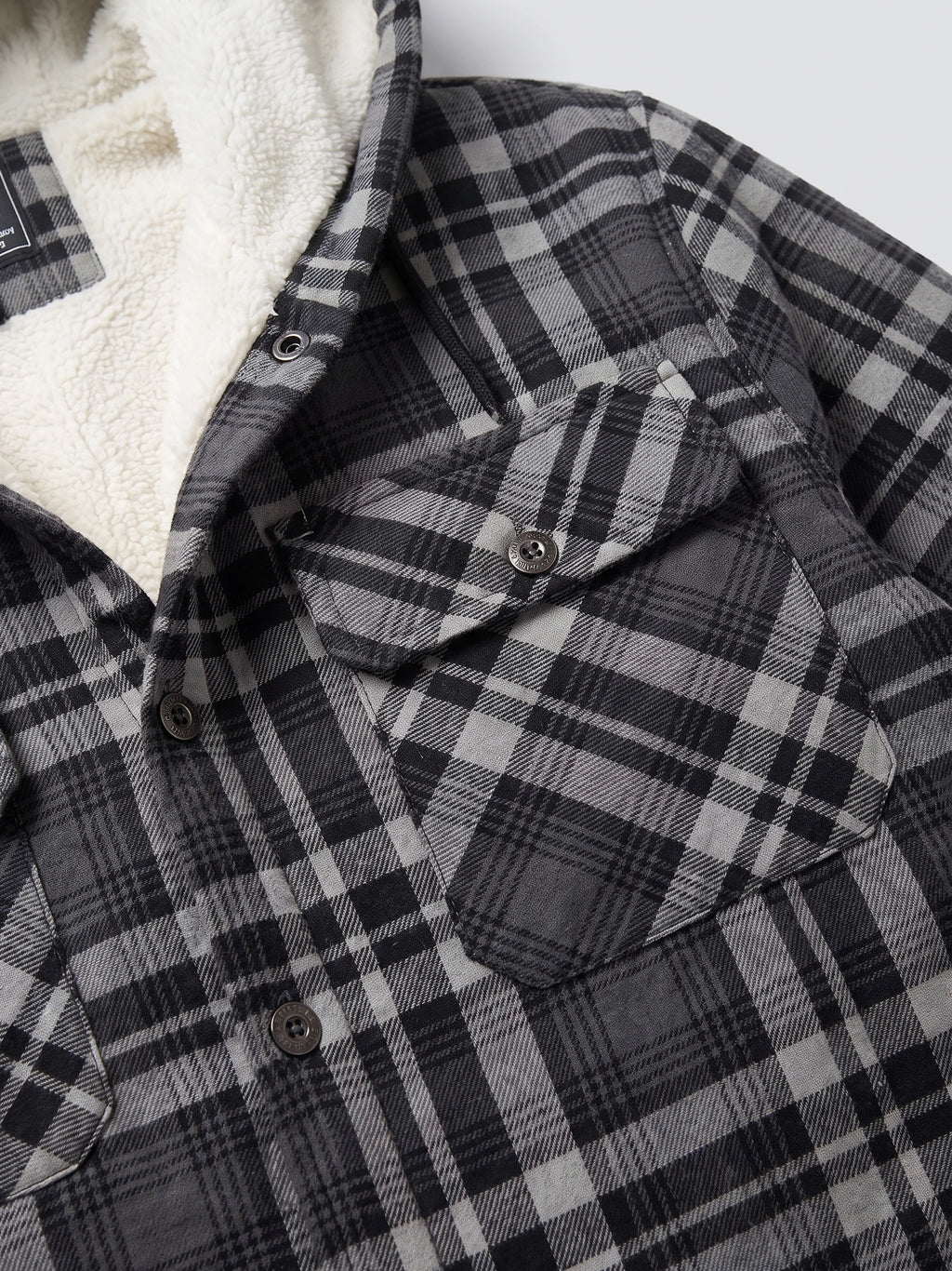 Close-up of the Gray Sherpa Lined Jacket showing the soft lining, plaid fabric, snap-button closure, and flap chest pocket.