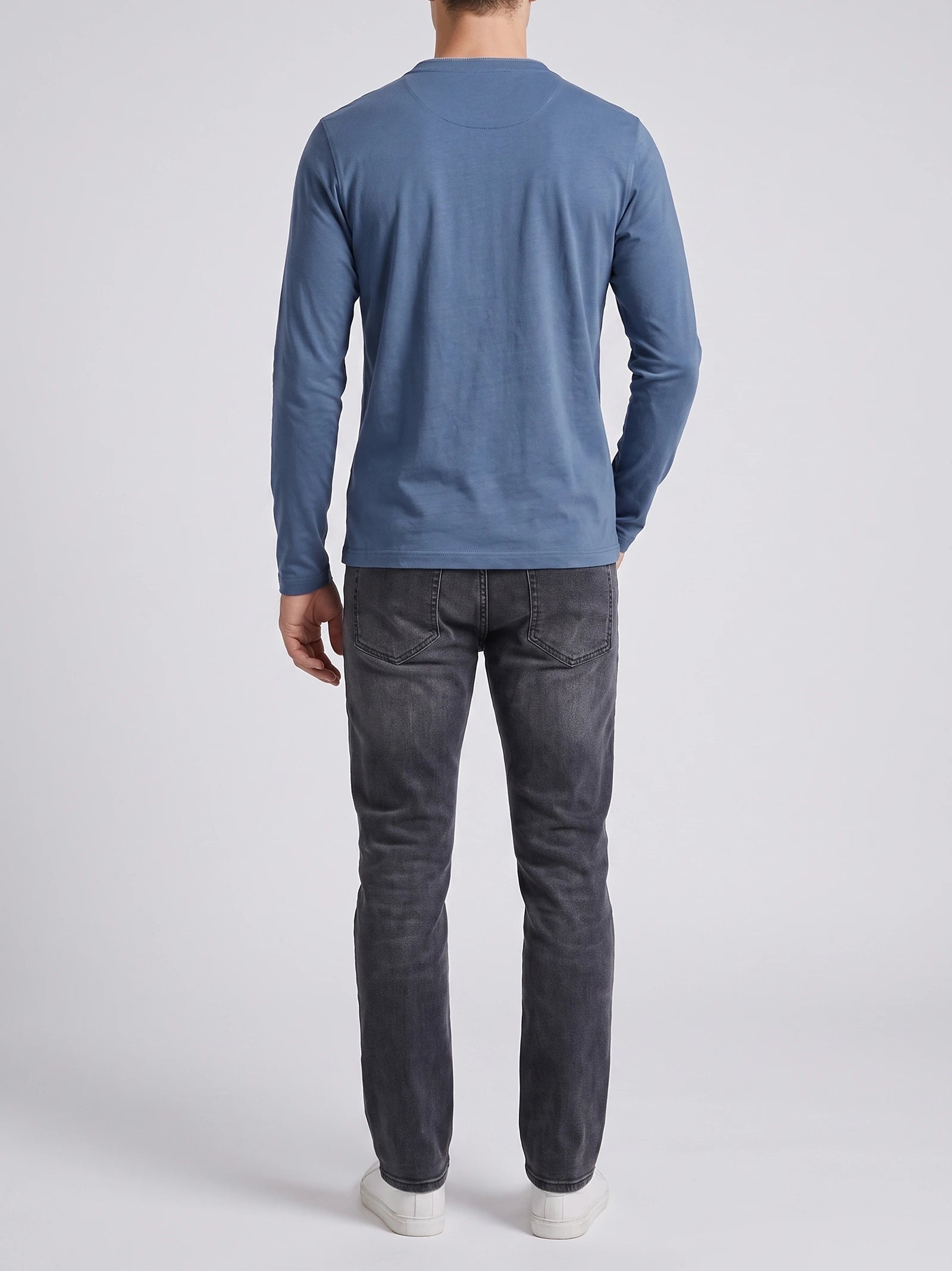 Rear studio view of a model wearing a Blue Slim-Fit cotton long-sleeve Henley shirt.