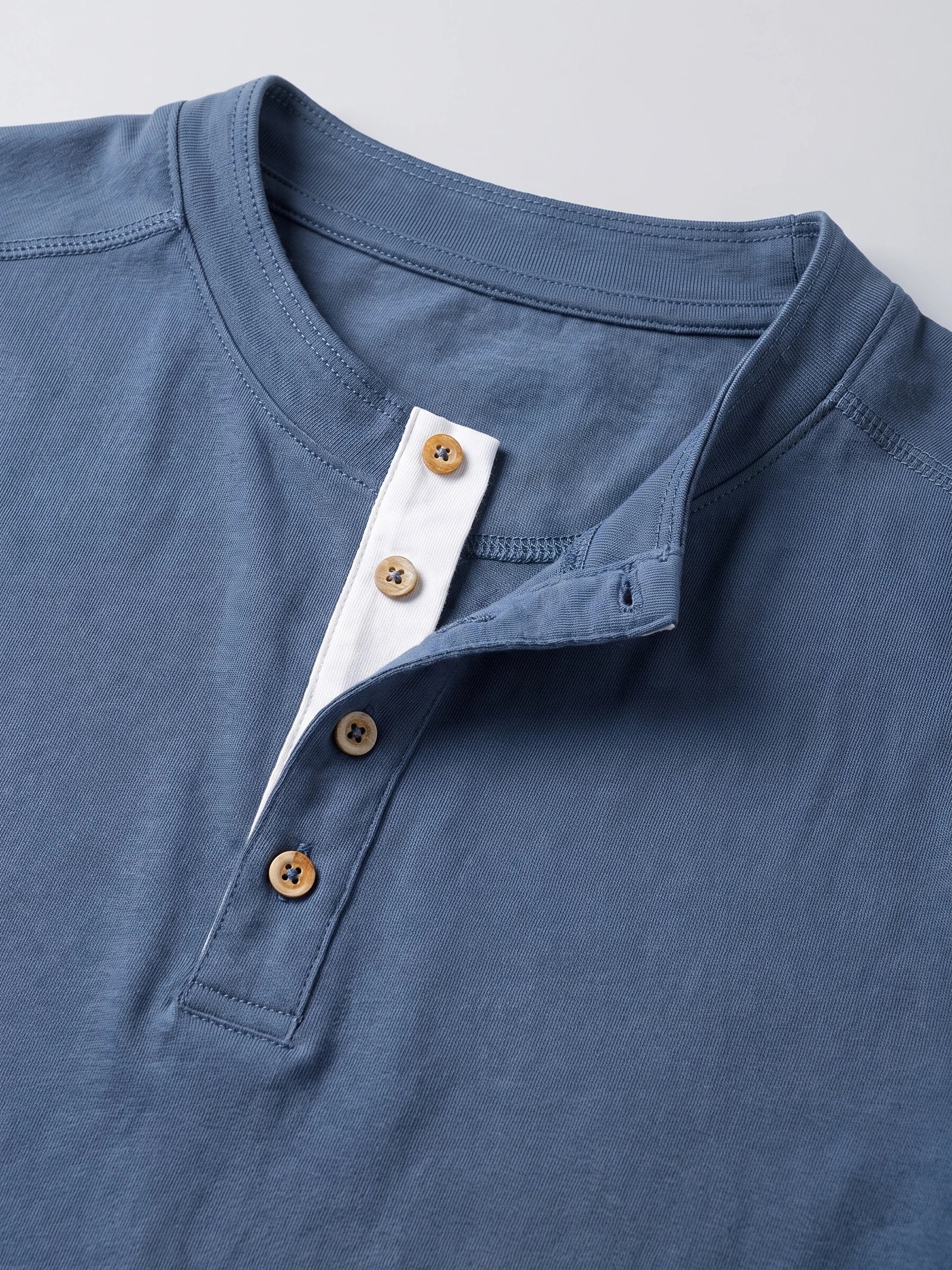 Close-up of the Blue cotton Slim-Fit men's Henley shirt, showing its ribbed crew neckline and button placket.