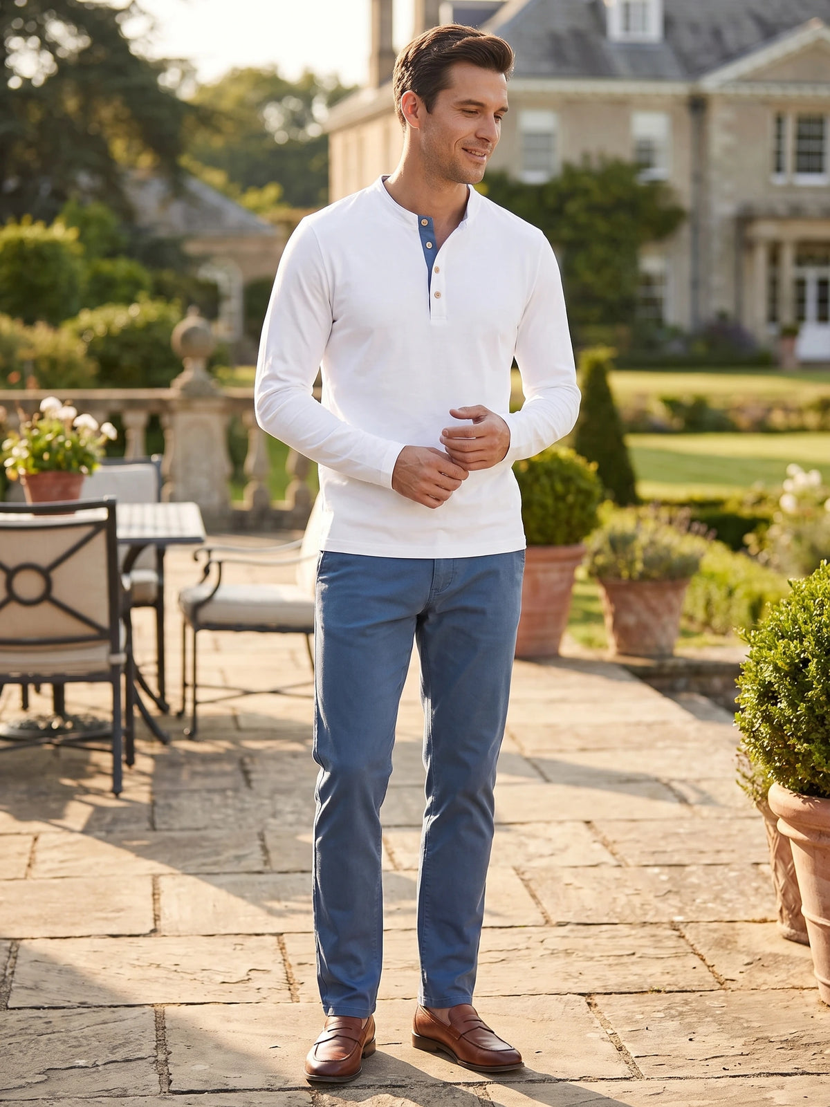 Man wearing a White Slim-Fit cotton long-sleeve Henley shirt while standing on a sunlit garden patio.