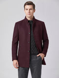 Front studio view of a model wearing a Wine wool overcoat with a stand collar, button front, zip pockets, and quilted inner layer.