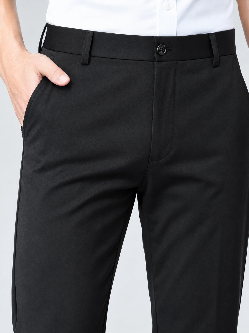 Close-up of Black men's pants showing the buttoned waistband, belt loops, fly, and side pocket.