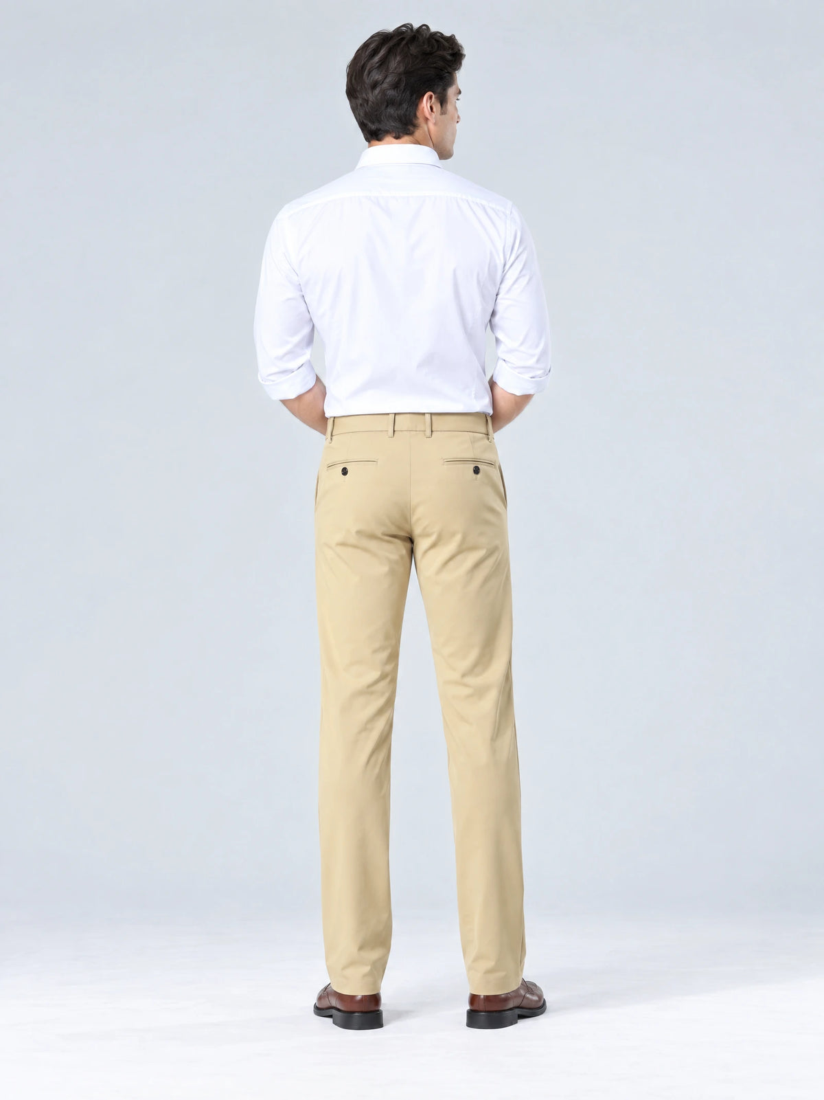 Rear studio view of a model wearing Khaki straight-fit men's pants with buttoned back welt pockets.
