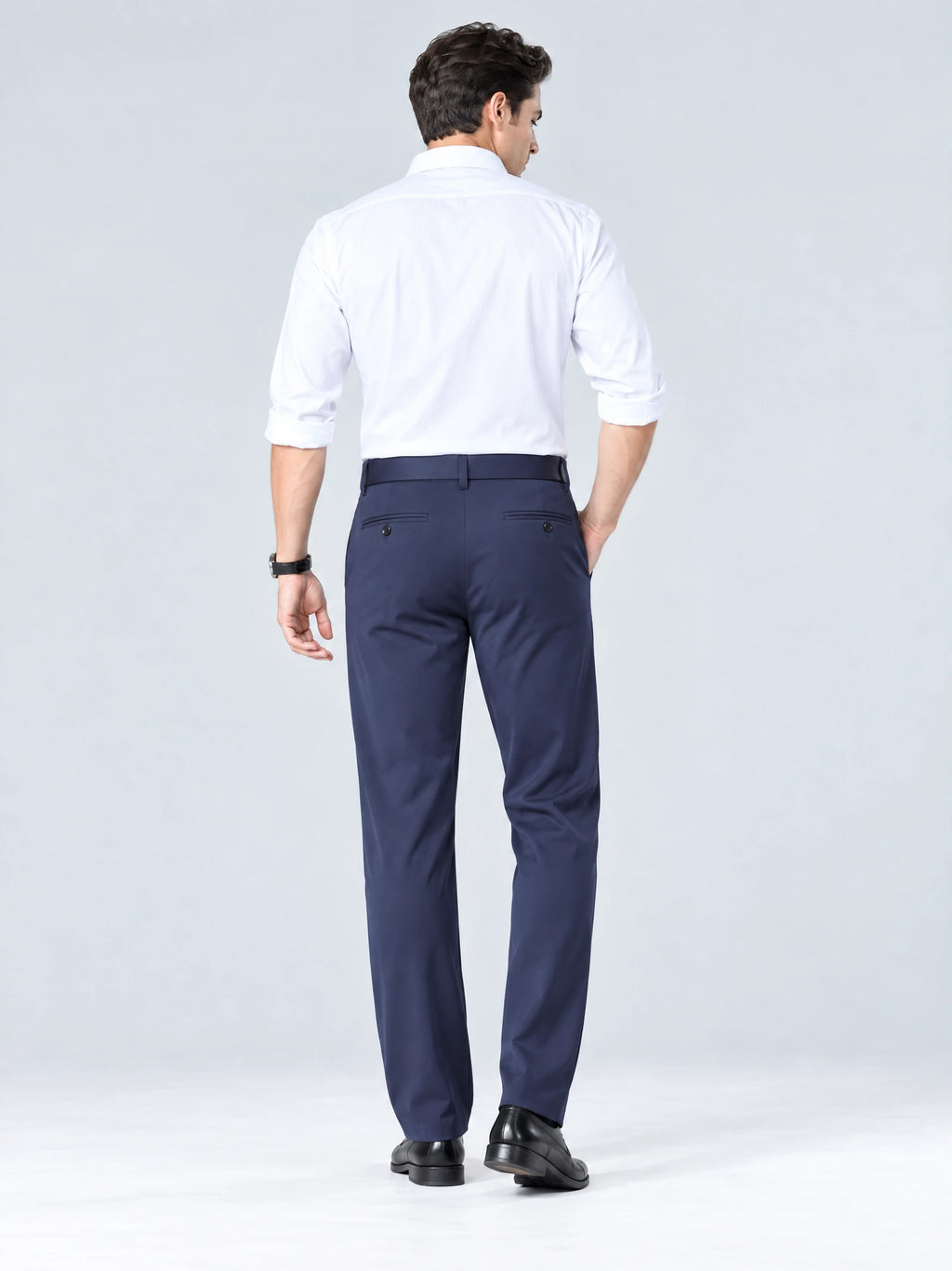 Rear studio view of a model wearing Navy straight-fit men's pants with buttoned back welt pockets.