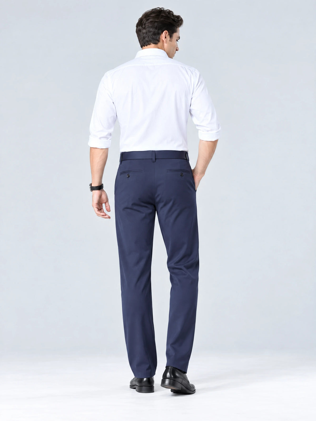 Rear studio view of a model wearing Navy straight-fit men's pants with buttoned back welt pockets.