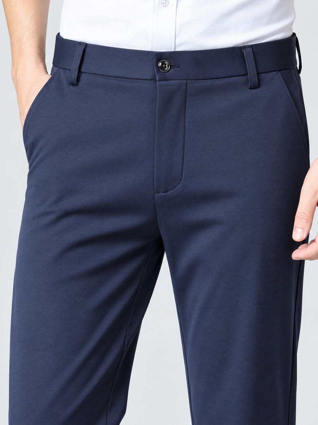 Close-up of Navy men's pants showing the button waistband, belt loops, fly, and side pockets.